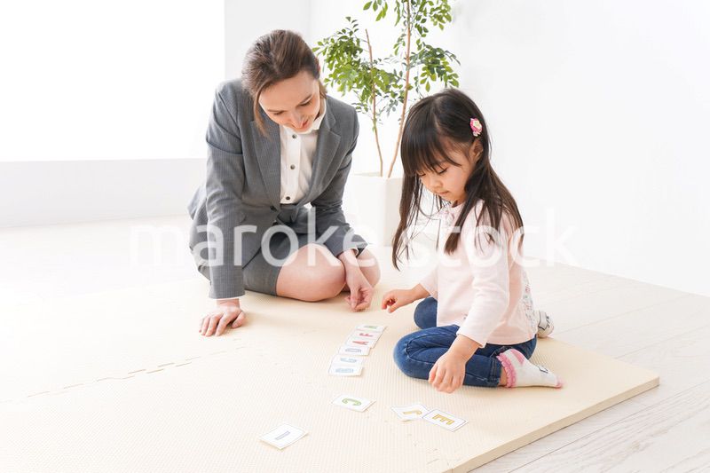 英語教室でネイティブ教師の授業を受ける子ども