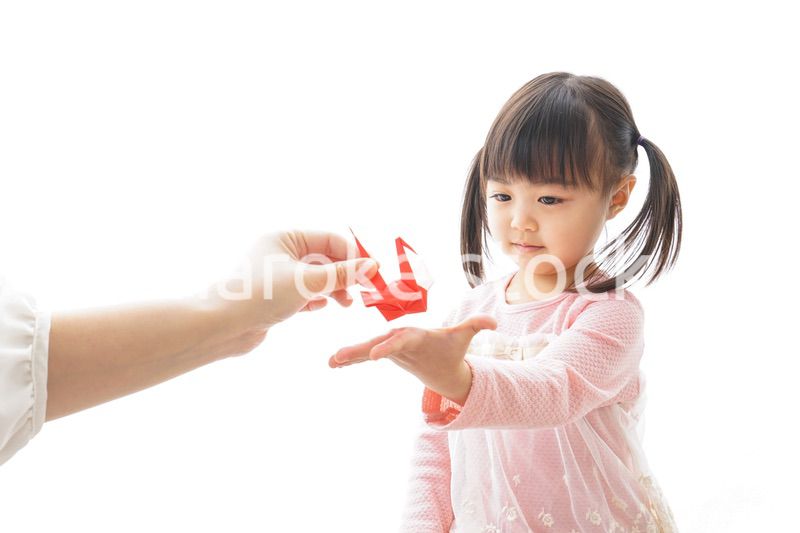 つるの折り紙を持つ子ども