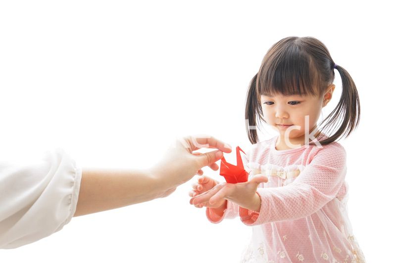 つるの折り紙を持つ子ども
