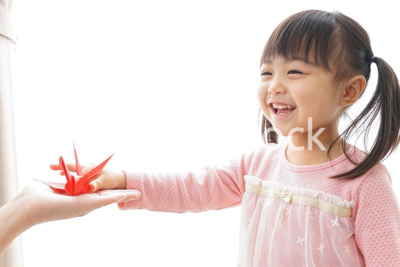 つるの折り紙を持つ子ども
