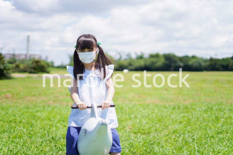 コロナウイルスに気をつけながら公園で遊ぶ子供