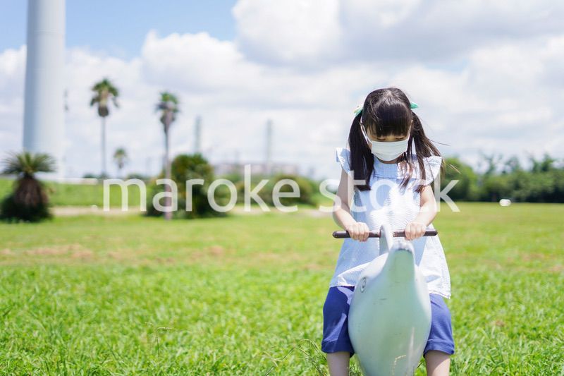 コロナウイルスに気をつけながら公園で遊ぶ子供
