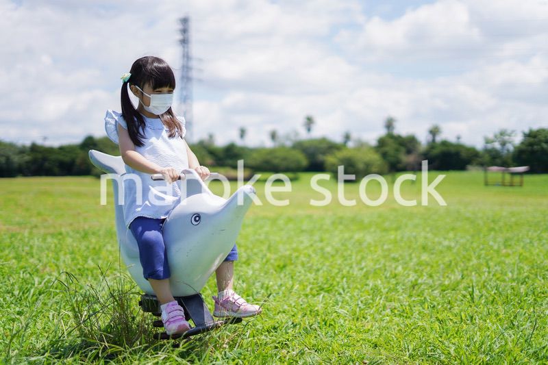 コロナウイルスに気をつけながら公園で遊ぶ子供