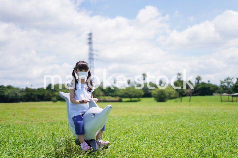 コロナウイルスに気をつけながら公園で遊ぶ子供