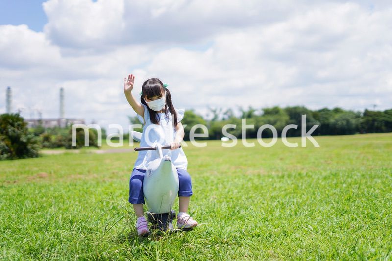 コロナウイルスに気をつけながら公園で遊ぶ子供