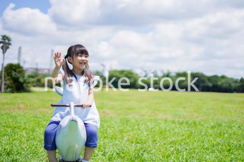 外の遊具で遊ぶ小さな女の子