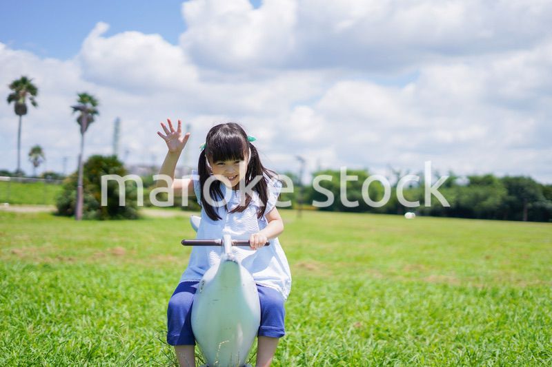 外の遊具で遊ぶ小さな女の子