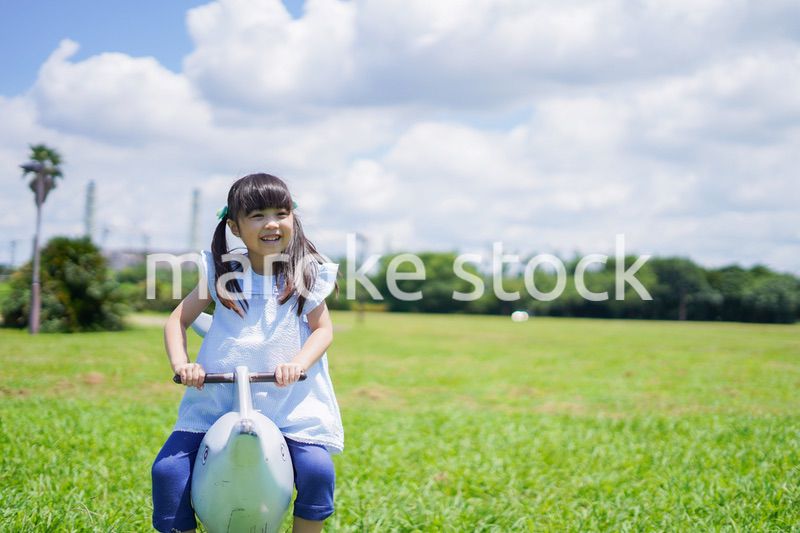 外の遊具で遊ぶ小さな女の子