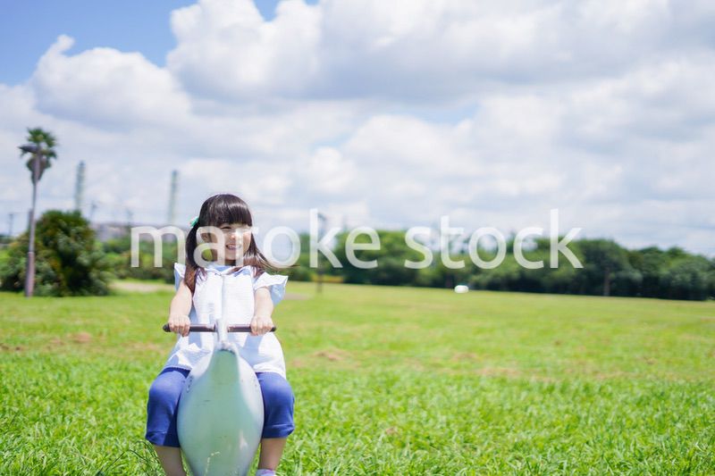 外の遊具で遊ぶ小さな女の子