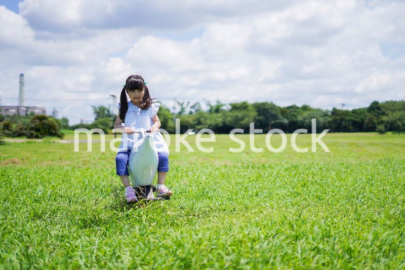 外の遊具で遊ぶ小さな女の子