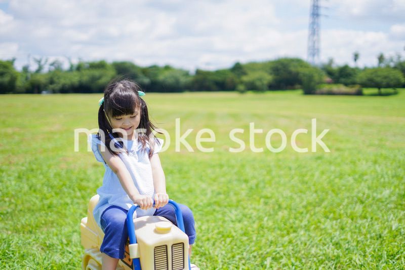 外の遊具で遊ぶ小さな女の子