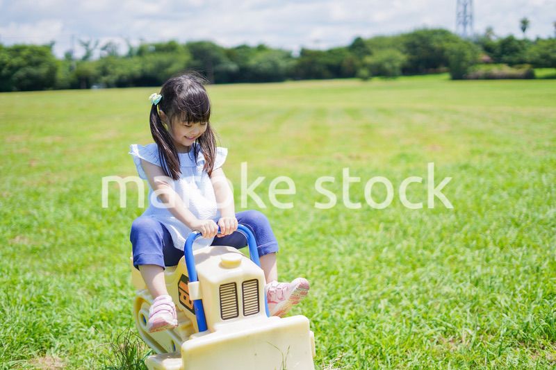 外の遊具で遊ぶ小さな女の子