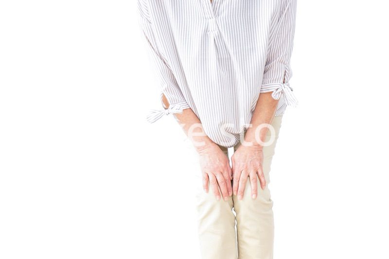 膝の痛みを感じる高齢者の女性