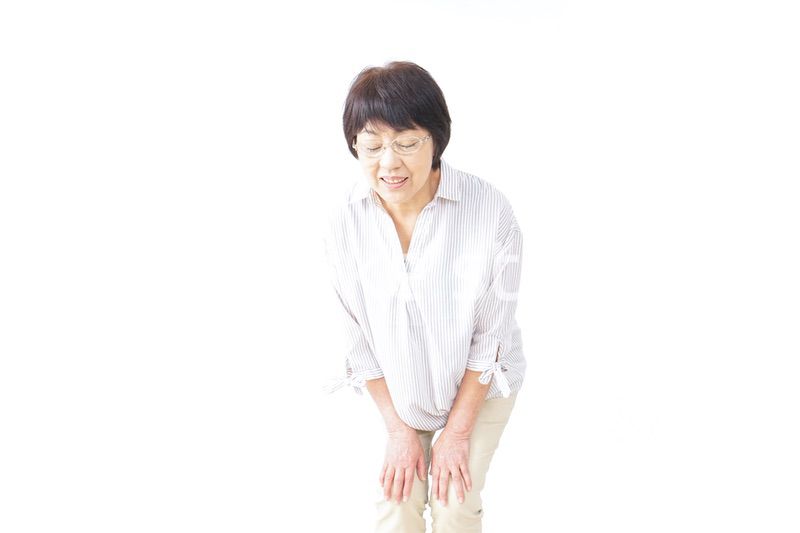膝の痛みを感じる高齢者の女性