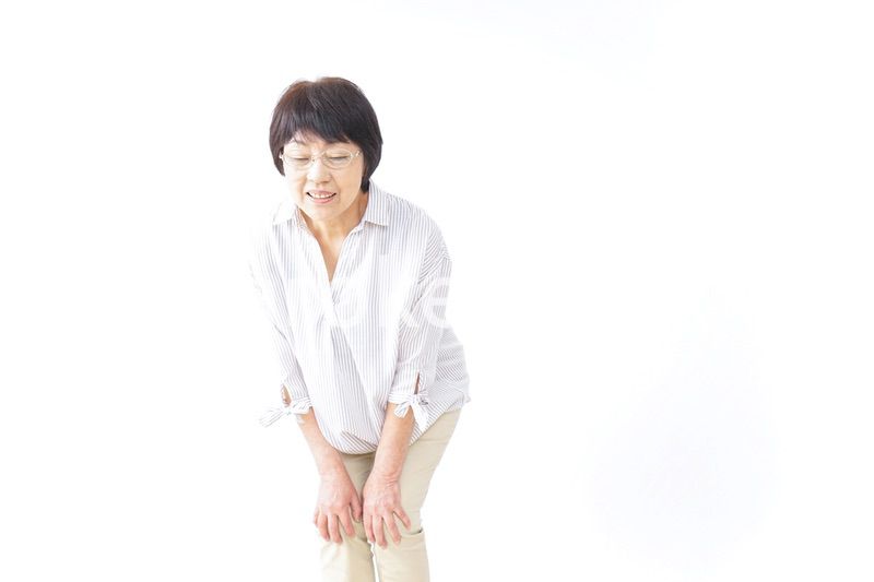 膝の痛みを感じる高齢者の女性