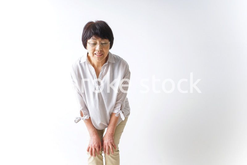 膝の痛みを感じる高齢者の女性