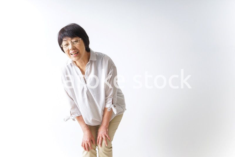 膝の痛みを感じる高齢者の女性