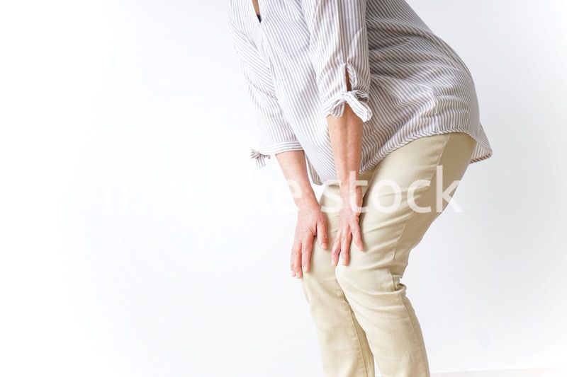 膝の痛みを感じる高齢者の女性