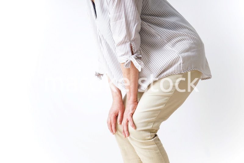 膝の痛みを感じる高齢者の女性