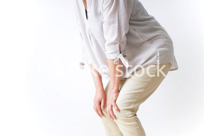 膝の痛みを感じる高齢者の女性