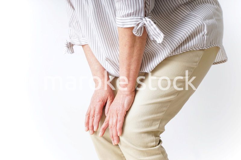 膝の痛みを感じる高齢者の女性