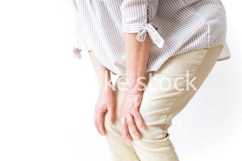 膝の痛みを感じる高齢者の女性