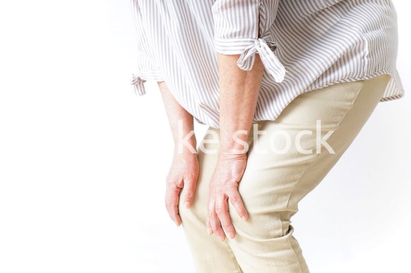 膝の痛みを感じる高齢者の女性