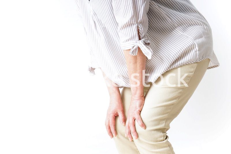 膝の痛みを感じる高齢者の女性