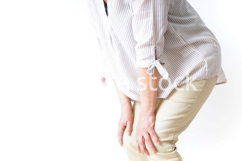 膝の痛みを感じる高齢者の女性