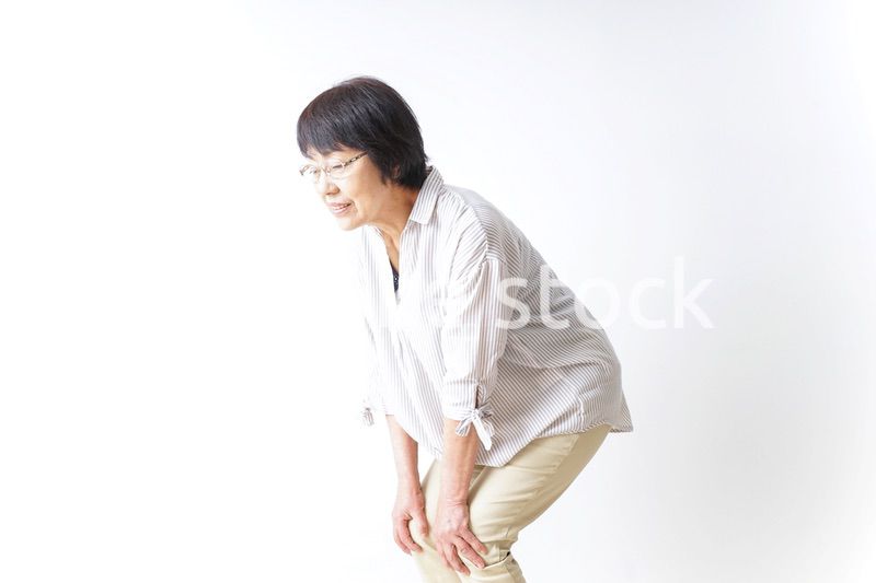 膝の痛みを感じる高齢者の女性
