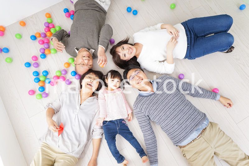 部屋で寝転ぶ三世代の家族