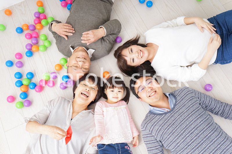 部屋で寝転ぶ三世代の家族