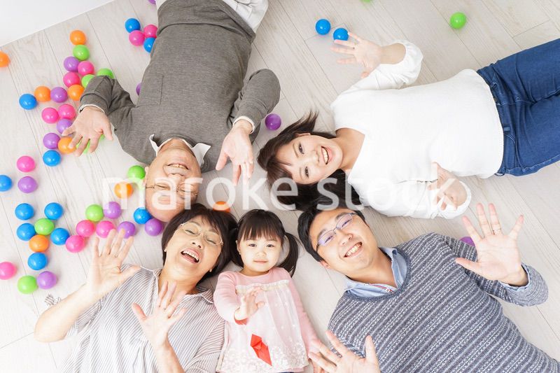 部屋で寝転ぶ三世代の家族