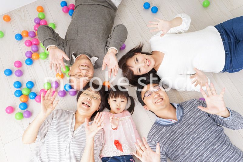 部屋で寝転ぶ三世代の家族