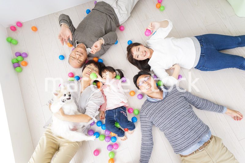 部屋で寝転ぶ三世代の家族