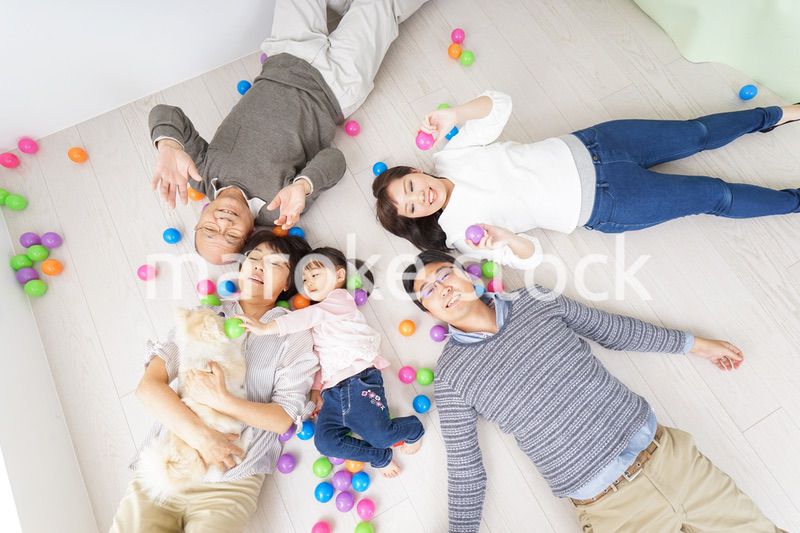 部屋で寝転ぶ三世代の家族