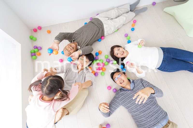 部屋で寝転ぶ三世代の家族