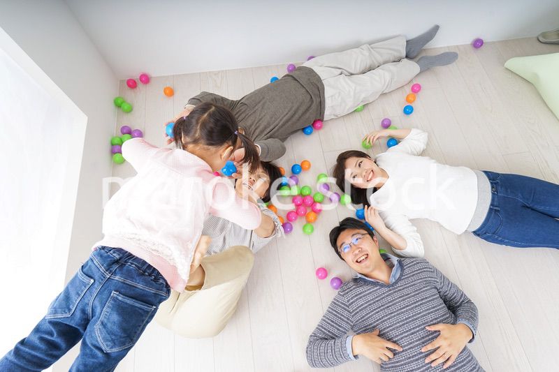 部屋で寝転ぶ三世代の家族