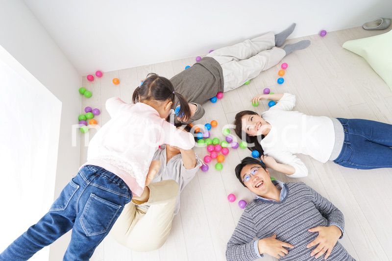 部屋で寝転ぶ三世代の家族