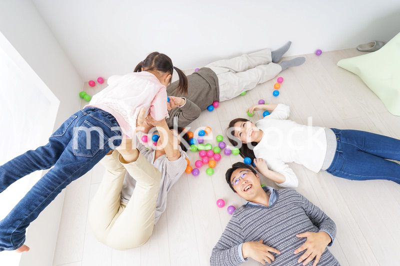 部屋で寝転ぶ三世代の家族