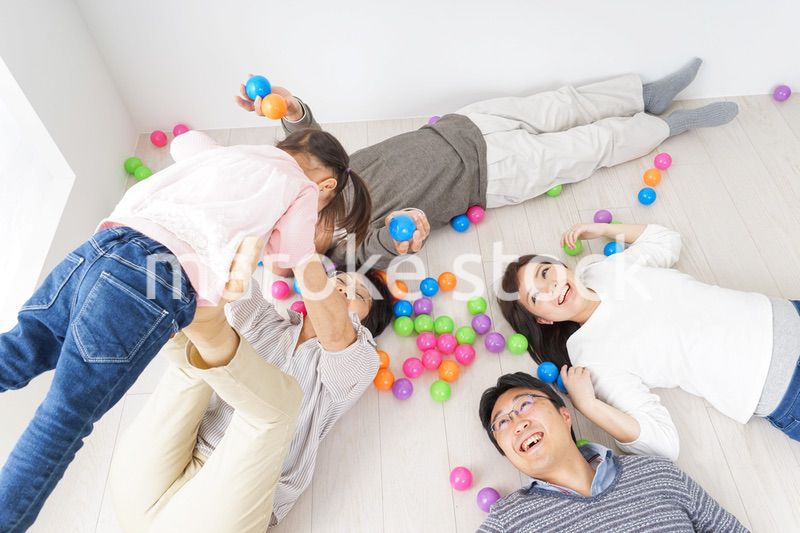 部屋で寝転ぶ三世代の家族