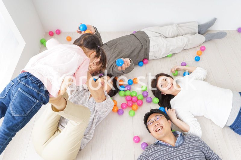 部屋で寝転ぶ三世代の家族