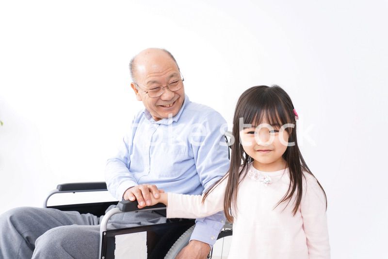 車椅子に乗る高齢男性と女の子