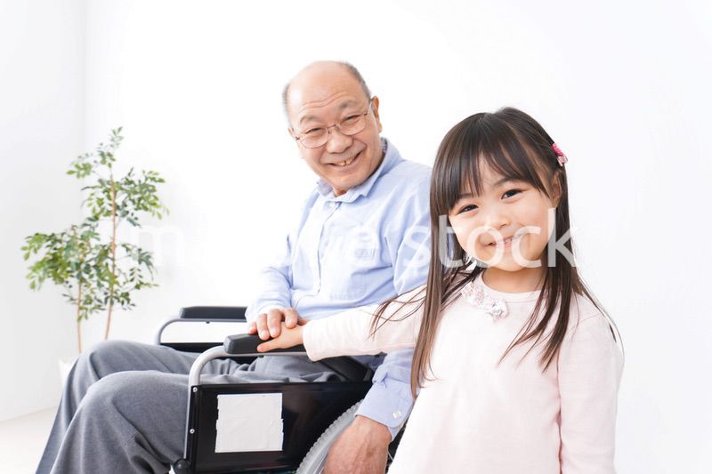 車椅子に乗る高齢男性と女の子