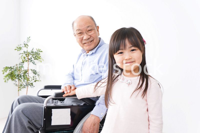 車椅子に乗る高齢男性と女の子