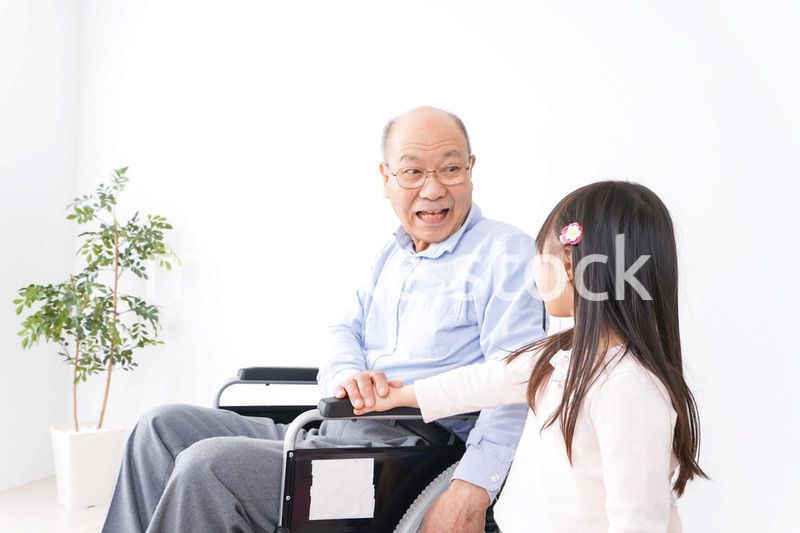 車椅子に乗る高齢男性と女の子