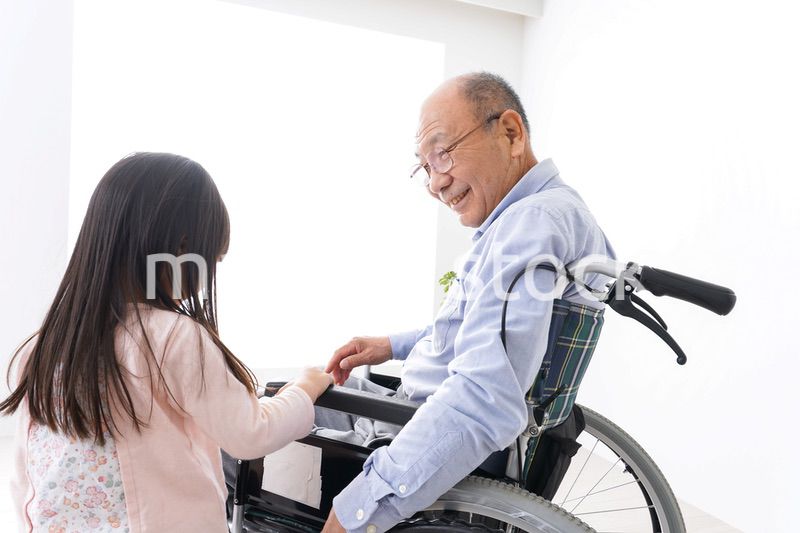 車椅子に乗る高齢男性と女の子