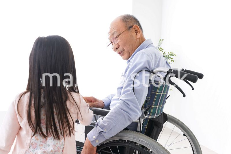 車椅子に乗る高齢男性と女の子