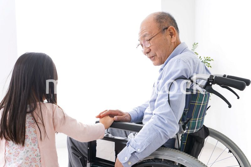 車椅子に乗る高齢男性と女の子