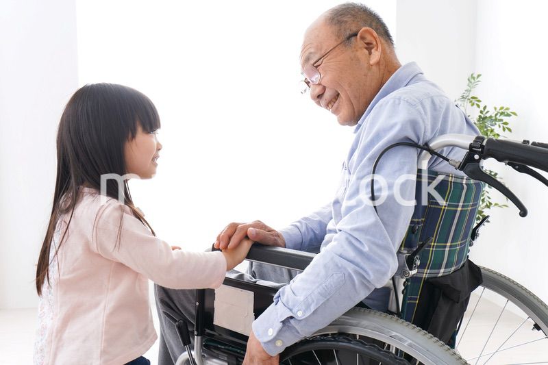 車椅子に乗る高齢男性と女の子